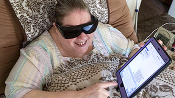 Blind woman listening to a conversation on her iPad.