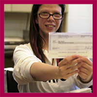 Woman holding check from employment earnings.